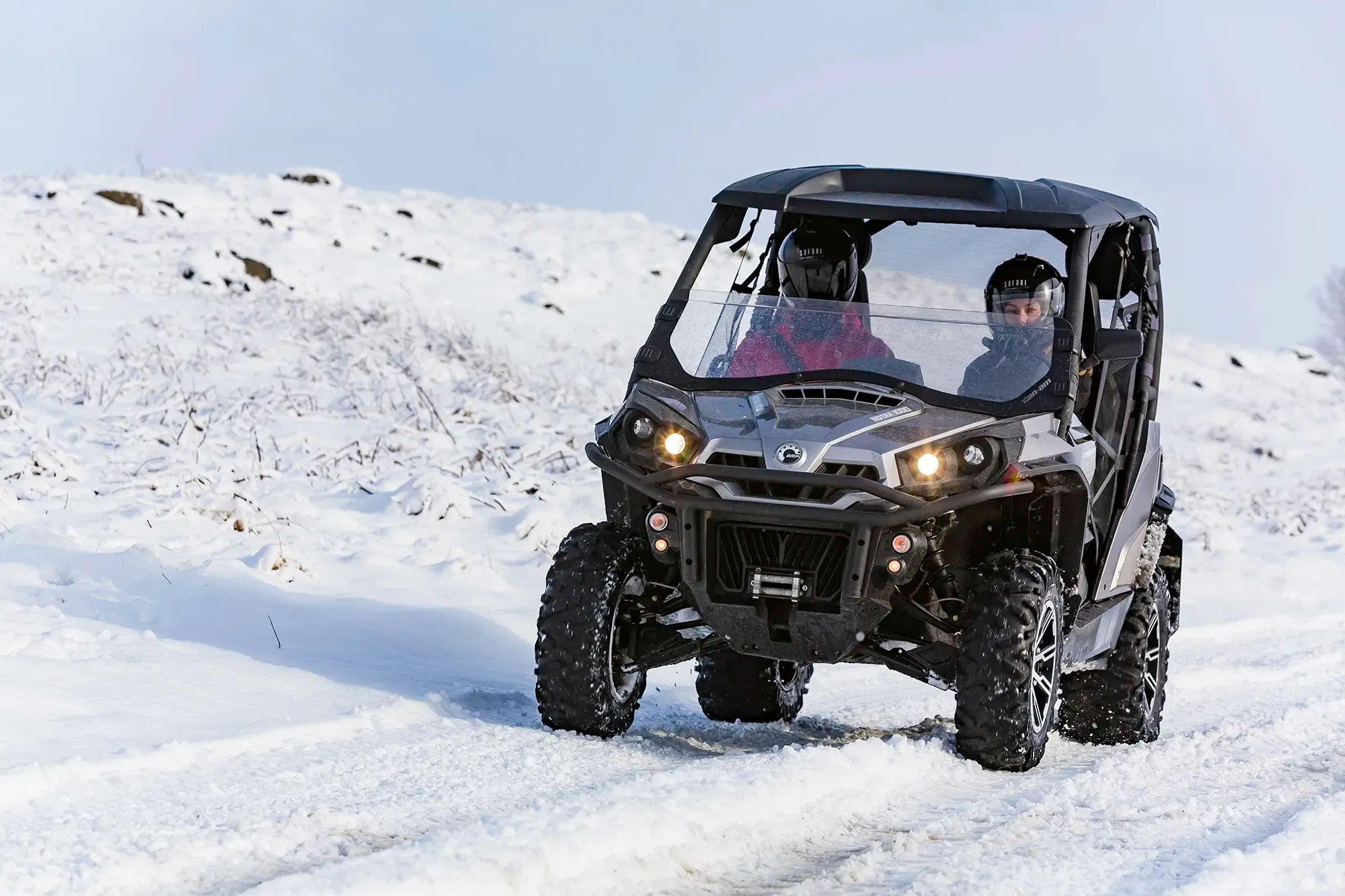 Black buggy with its headlights on driving through snow