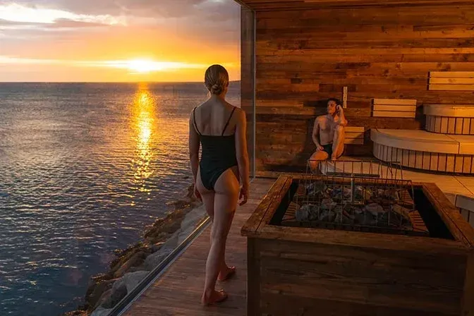 Woman walking into the Sky Lagoon sauna at sunset