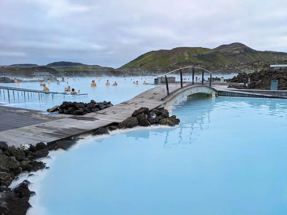 Wooden bridge over the Blue Lagoon with bathers in the distance
