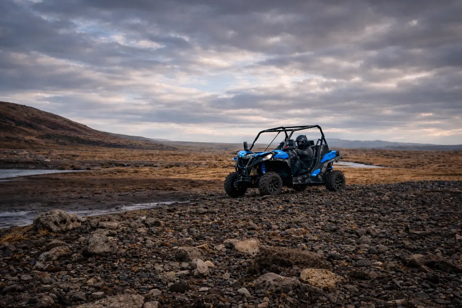 Blue buggy on a rocky plain under a cloudy sky