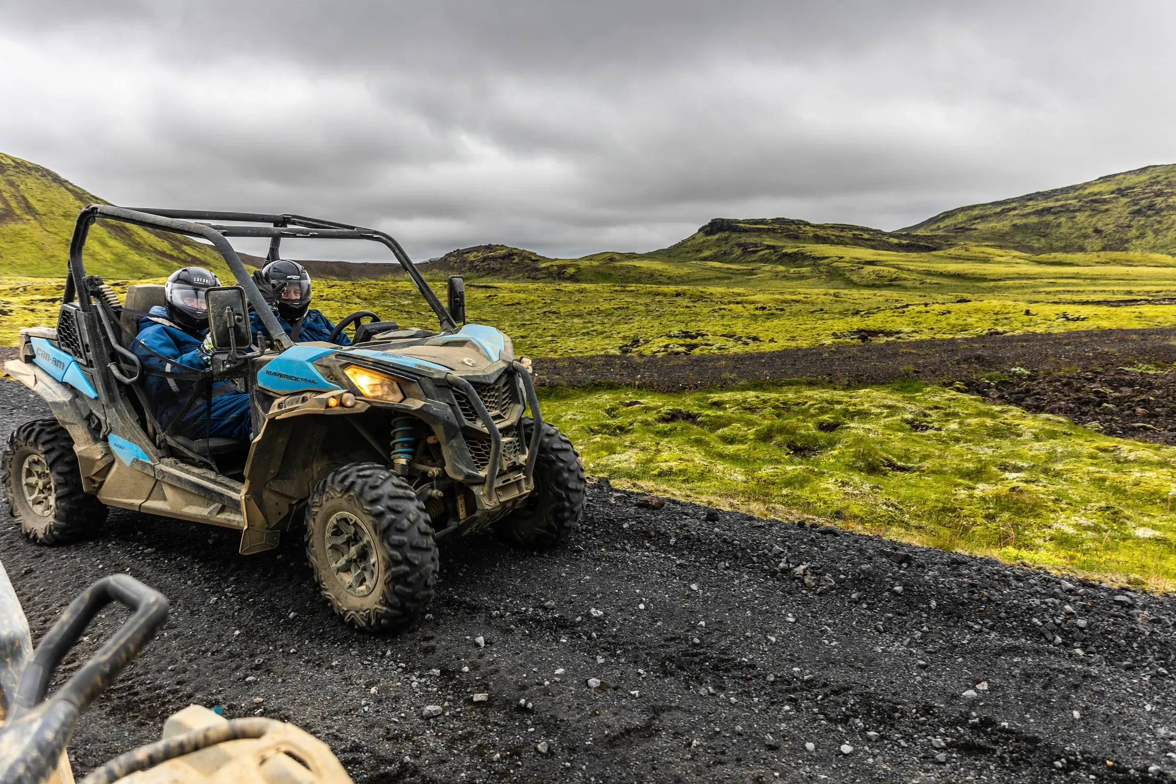 Buggy on a gravel track through green hills